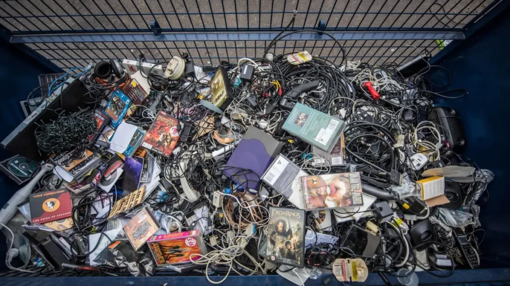 E Waste Buyers Thiruvananthapuram in Kerala 10 A large commercial metal bin filled with mixed electronic scrap, tangled wires, power adapters, and obsolete office devices